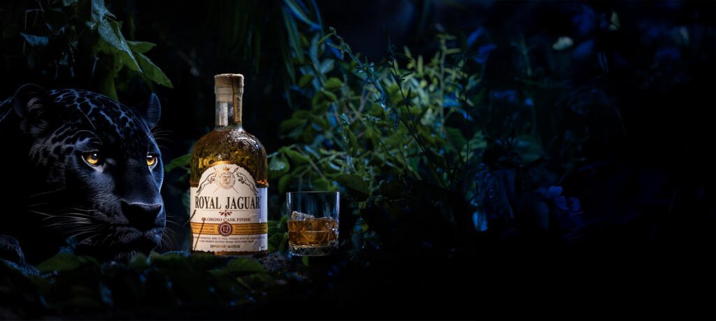 Royal Jaguar whisky bottle with a glass of scotch, set in a rainforest with a black jaguar watching closely, symbolizing power, courage, and legacy.